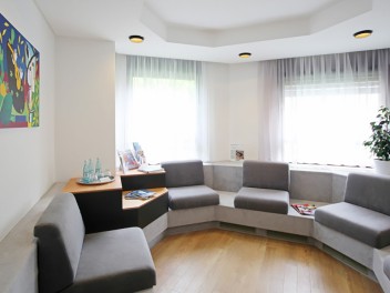 Wartezimmer mit runder Sitzecke in Grau